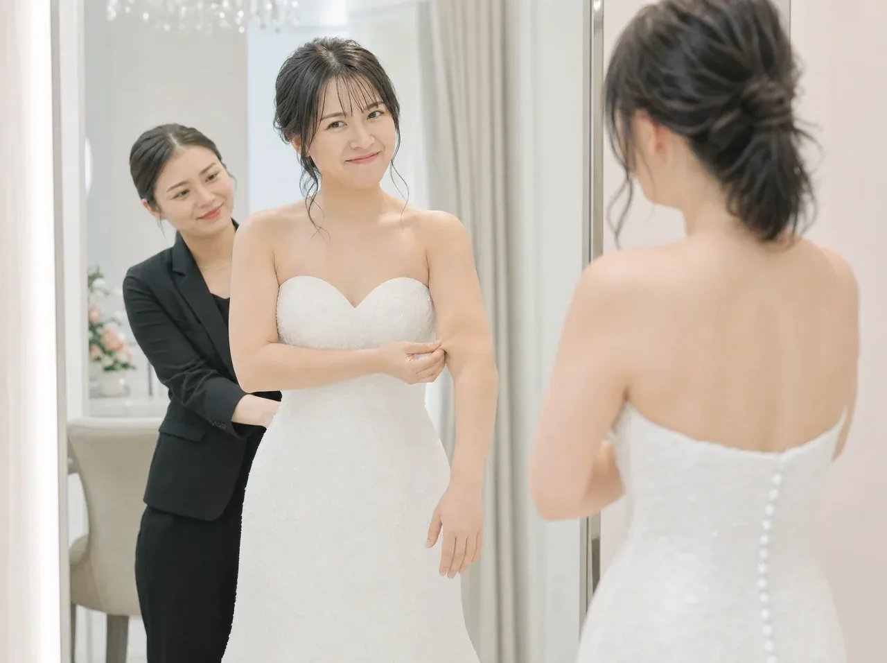 ドレス試着で二の腕を気にする花嫁とサポートするスタッフ
